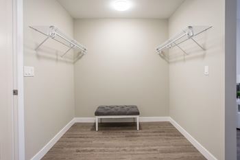 A room with a bench and two shelves on the wall.